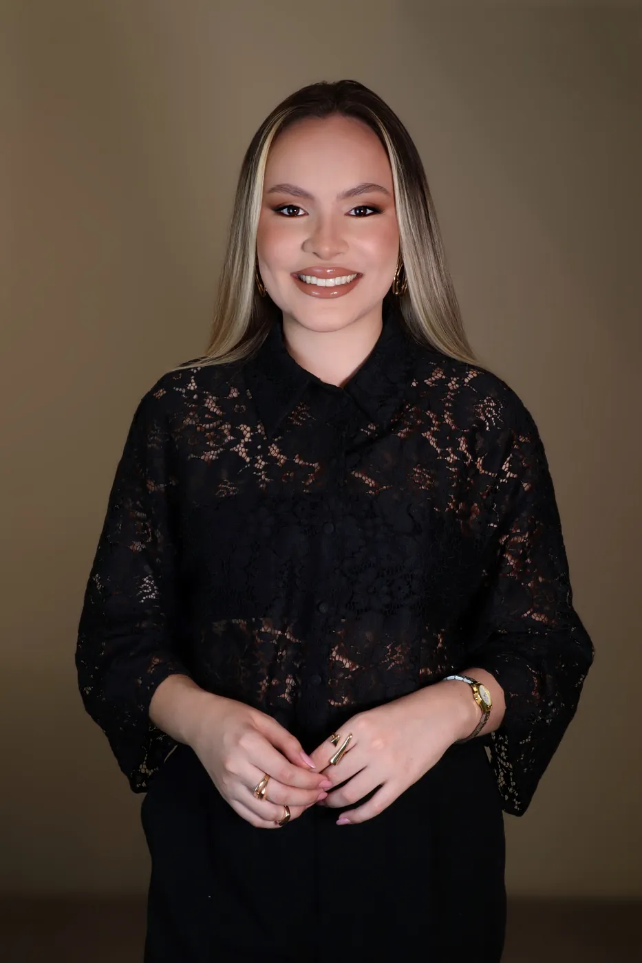 Dra. Carolina Costa em pé, sorrindo, com as mãos unidas